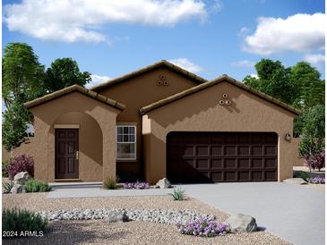 Single-story home with brown exterior, two-car garage, and landscaping at 9710 W Agora Ln, Tolleson, AZ 85353