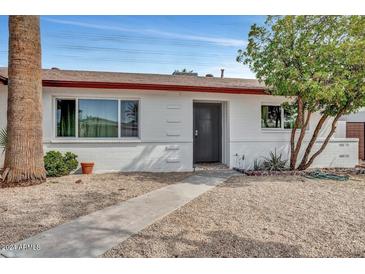 White single story home with gray door and walkway at 2013 N 66Th St, Scottsdale, AZ 85257