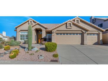 Tan two-story house with three-car garage and desert landscaping at 11104 E White Feather Ln, Scottsdale, AZ 85262