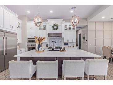 Modern kitchen with large island, stainless steel appliances, and white cabinetry at 21121 E Marsh Rd, Queen Creek, AZ 85142
