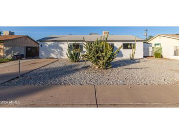 Updated single-story home with desert landscaping and a large front yard at 3350 W Wethersfield Rd, Phoenix, AZ 85029