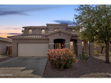 Two-story house with a large front yard, attached garage, and neutral color scheme at 17329 W Banff Ln, Surprise, AZ 85388