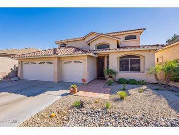 Two-story house with tile roof, attached two-car garage, and desert landscaping at 2451 E Darrel Rd, Phoenix, AZ 85042