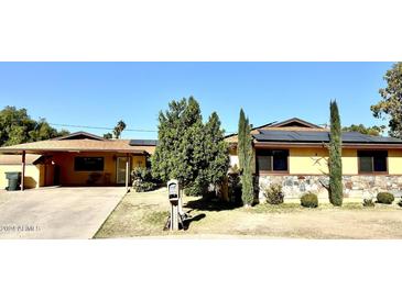 Ranch style home with solar panels, mature landscaping, and a paved driveway at 404 E Paseo De Isabella --, Casa Grande, AZ 85122