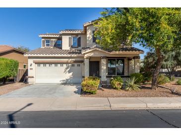 Two-story house with a three-car garage and landscaping at 18080 W Desert Ln, Surprise, AZ 85388