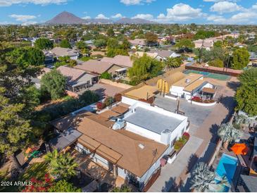 Aerial view of a house with a pool, basketball court, and large backyard at 8340 E Thomas Rd, Scottsdale, AZ 85251