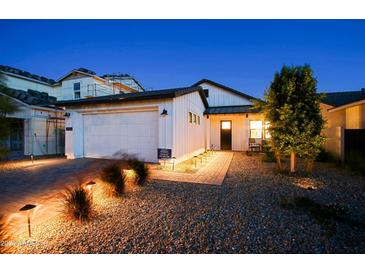 Stunning curb appeal with modern farmhouse exterior, landscaping, and lighting at 17221 W Middlebury St, Surprise, AZ 85388