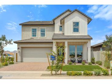 Two-story farmhouse-style home with a gray and white exterior, and a landscaped front yard at 26048 S 229Th Pl, Queen Creek, AZ 85142