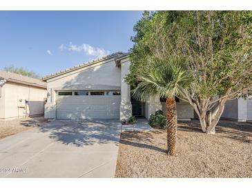 Front view of a single-story house with a two-car garage and desert landscaping at 1035 S 99Th Pl, Mesa, AZ 85208