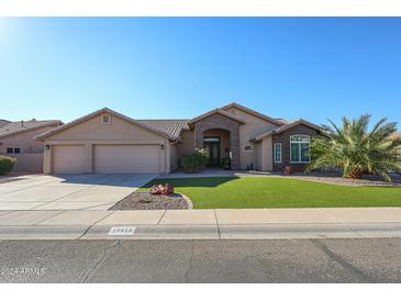 Beautiful single-story home with a three-car garage and lush lawn at 19418 N 86Th Dr, Peoria, AZ 85382