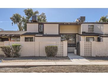 Tan two-story townhome with a gated entry and landscaping at 3120 N 67Th Ln # 47, Phoenix, AZ 85033