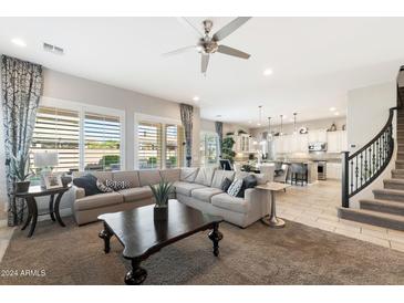 Open living room and kitchen area with large windows, neutral colors, and ample natural light at 20230 E Escalante Rd, Queen Creek, AZ 85142