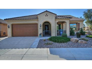 Single-story home with attractive landscaping and a two-car garage at 7075 W Noble Prairie Way, Florence, AZ 85132