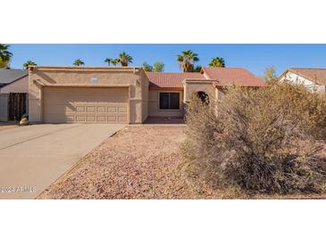 House exterior with a two-car garage and desert landscaping at 10096 N 63Rd Ave, Glendale, AZ 85302