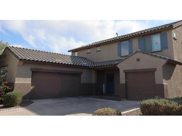 Two-story house with taupe exterior, two-car garage, and landscaping at 10551 W Crown King Rd, Tolleson, AZ 85353