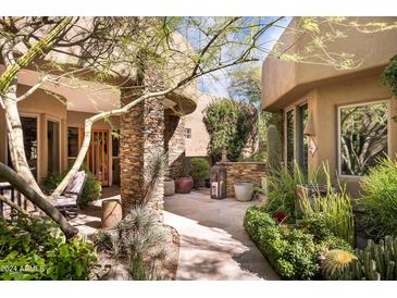 Landscaped courtyard with stone columns and pathway at 9722 E Mark Ln, Scottsdale, AZ 85262