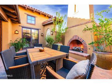 Inviting patio with fireplace and dining area, perfect for outdoor entertaining at 10575 E Rising Sun Dr, Scottsdale, AZ 85262