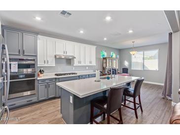 Modern kitchen with two-toned cabinets, island, and stainless steel appliances at 19950 W Heatherbrae Dr, Litchfield Park, AZ 85340