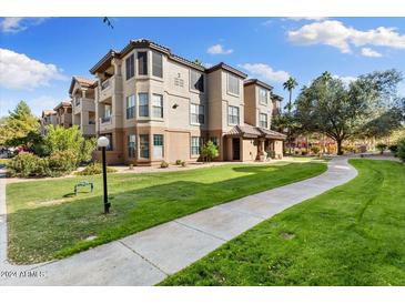 Two-story condo building with landscaped grounds and walkway at 14950 W Mountain View Blvd # 2112, Surprise, AZ 85374