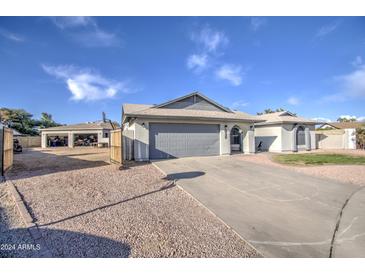 Single story home with gray garage door, basketball court, and spacious yard at 8152 W Sierra Vista Dr, Glendale, AZ 85303