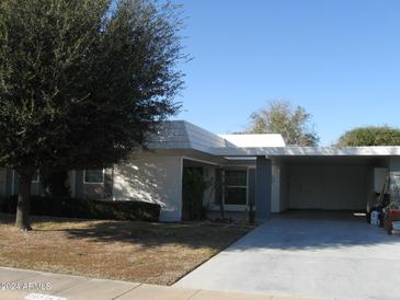 Ranch style home with carport and mature landscaping at 10334 W Highwood Ln, Sun City, AZ 85373