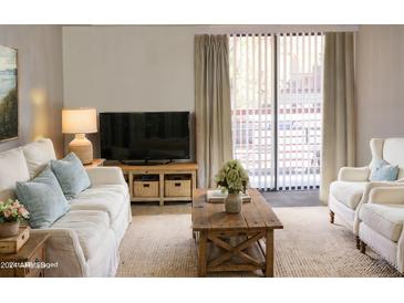 Living room with light colored couches and wooden coffee table at 3434 W Danbury Dr # A204, Phoenix, AZ 85053