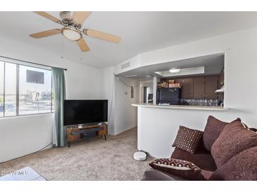 Living room features a TV, couch, and ceiling fan at 3601 W Tierra Buena Ln # 248, Phoenix, AZ 85053