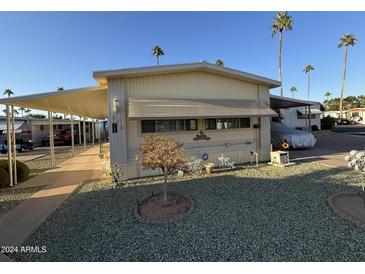 Single-wide manufactured home with carport and landscaped yard at 4065 E University Dr # 276, Mesa, AZ 85205