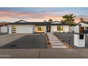 Stunning curb appeal featuring a modern white house with a landscaped front yard at 5030 E Winchcomb Dr, Scottsdale, AZ 85254