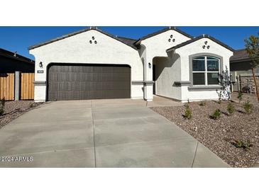 New single-story home with a two-car garage and desert landscaping at 18350 W Smoketree Dr, Wittmann, AZ 85361