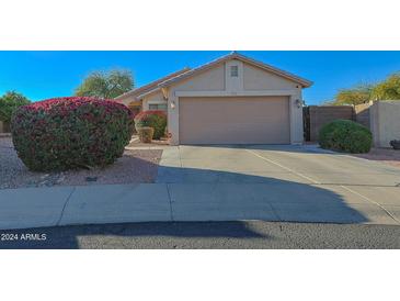 One-story house with a two-car garage and well-manicured landscaping at 13824 N 148Th Ln, Surprise, AZ 85379