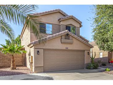 Two-story home with a two-car garage and palm trees in the front yard at 13852 N 91St Ln, Peoria, AZ 85381