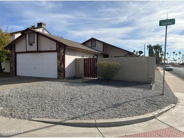 Single-story home with a two-car garage and gravel landscaping at 4201 E Camino St, Mesa, AZ 85205