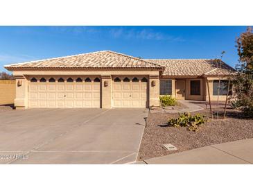 Beige house with three-car garage and desert landscaping at 4554 W Whitten Ct, Chandler, AZ 85226