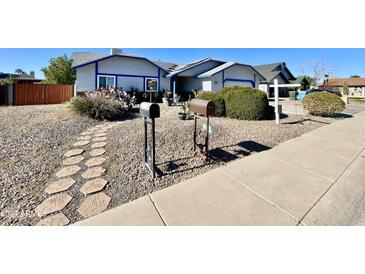 Landscaped front yard with stone pathway leading to the entrance of the home at 18024 N 36Th Ln, Glendale, AZ 85308