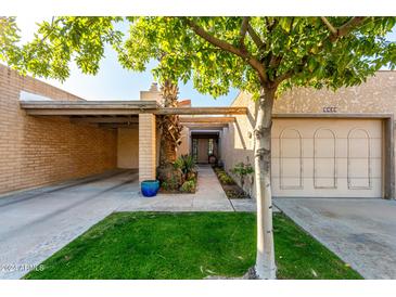 Front view of a charming condo with a landscaped walkway and attached garage at 5520 N 5Th Ln, Phoenix, AZ 85013