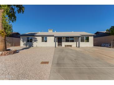 Newly renovated single-story home with a large driveway and landscaped yard at 7272 W College Dr, Phoenix, AZ 85033