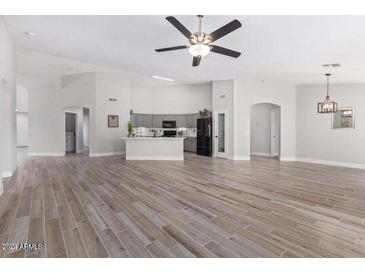 Open living room with tile floors and an island kitchen at 10417 E El Moro Ave, Mesa, AZ 85208