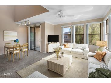 Bright living room with comfy sofas, a coffee table, and access to a balcony at 20100 N 78Th Pl # 2108, Scottsdale, AZ 85255