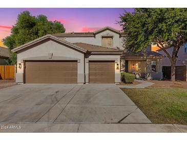 Two-story house with brown garage doors and well-maintained lawn at 16818 W Marconi Ave, Surprise, AZ 85388