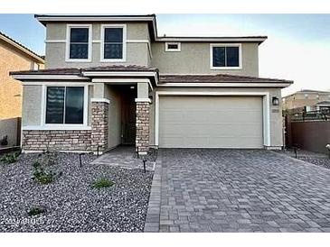 Two-story house with stone accents and a paved driveway at 31930 N 124Th Dr, Peoria, AZ 85383