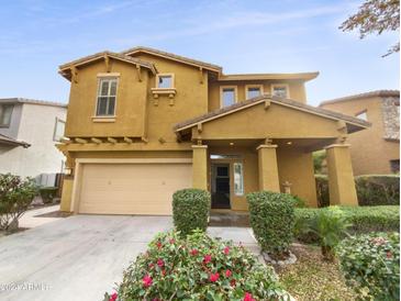 Two-story house with tan exterior, two-car garage, and landscaping at 4319 E Vaughn Ave, Gilbert, AZ 85234