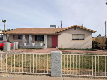 Ranch style home with red door, landscaping, and gated front yard at 1931 N Macdonald --, Mesa, AZ 85201