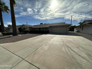 Ranch-style home with a large driveway and mature landscaping at 5725 E Covina Rd, Mesa, AZ 85205