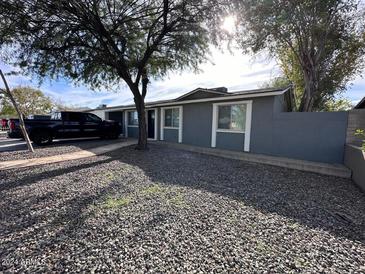 Gray house with a landscaped front yard, and a long driveway at 819 E Erie St, Chandler, AZ 85225