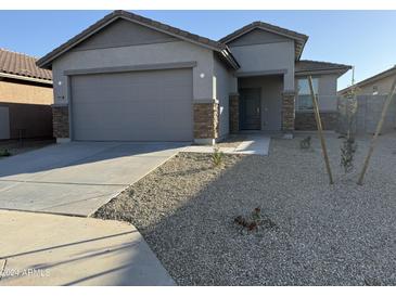 Single-story home with gray exterior, two-car garage, and small front yard at 17033 W Seldon Ln, Waddell, AZ 85355