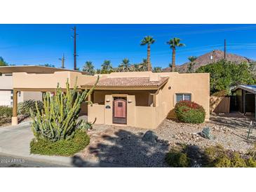 Charming stucco home with a red tile roof, landscaped yard, and a wooden door at 4620 E Montecito Ave, Phoenix, AZ 85018