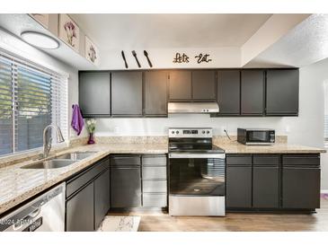 Modern kitchen with granite countertops and stainless steel appliances at 10827 N 65Th Ave, Glendale, AZ 85304