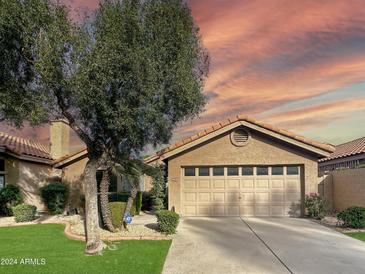 Beautiful home exterior with a two-car garage and well-manicured lawn at 5016 E Marconi Ave, Scottsdale, AZ 85254