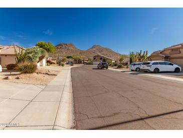 Quiet residential street with mountain views and parked cars at 6526 W Briles Rd, Phoenix, AZ 85083